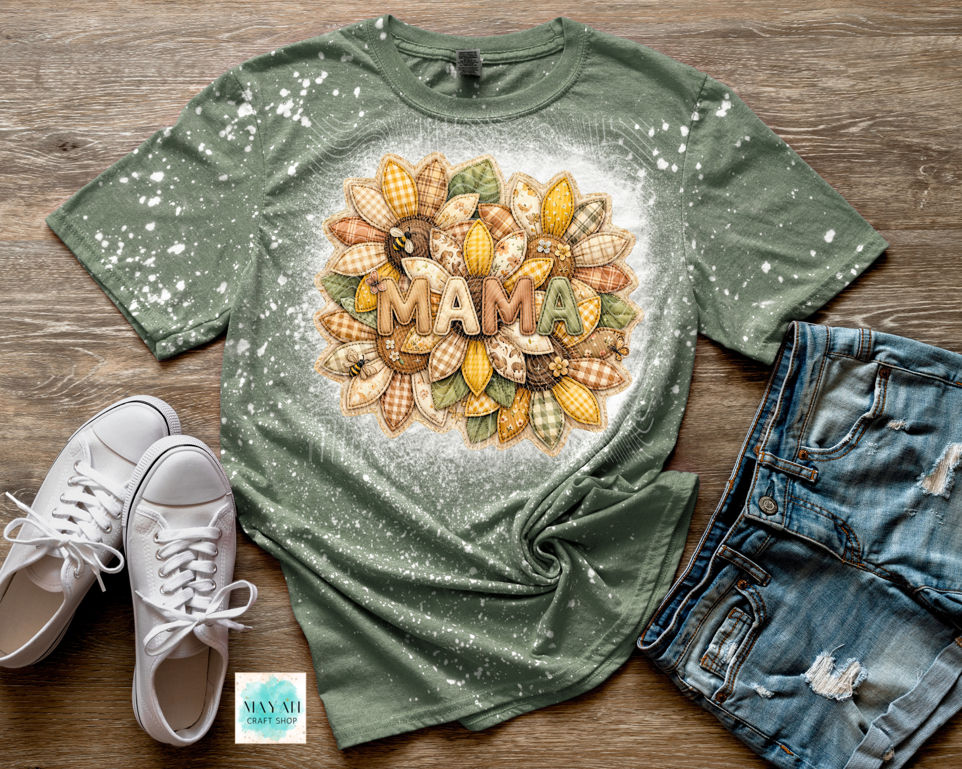 Green t-shirt with 'MAMA' design on a wooden surface with white sneakers and denim shorts.