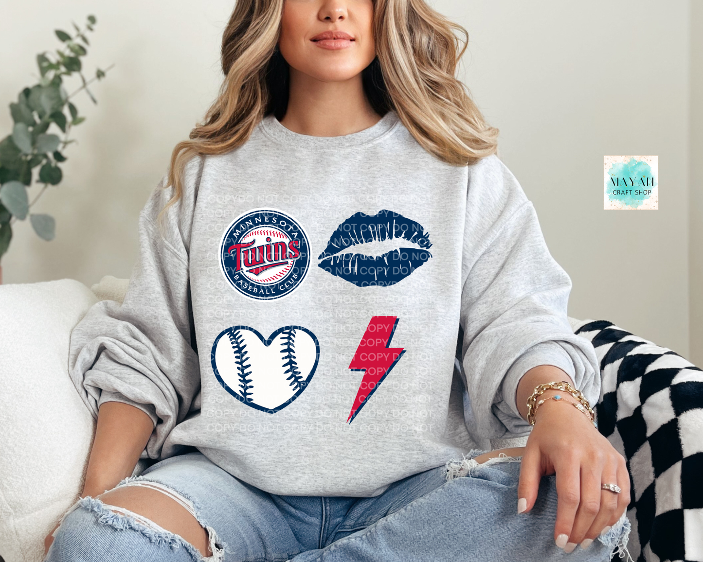 Woman wearing a gray sweatshirt with sports-themed graphics and text.