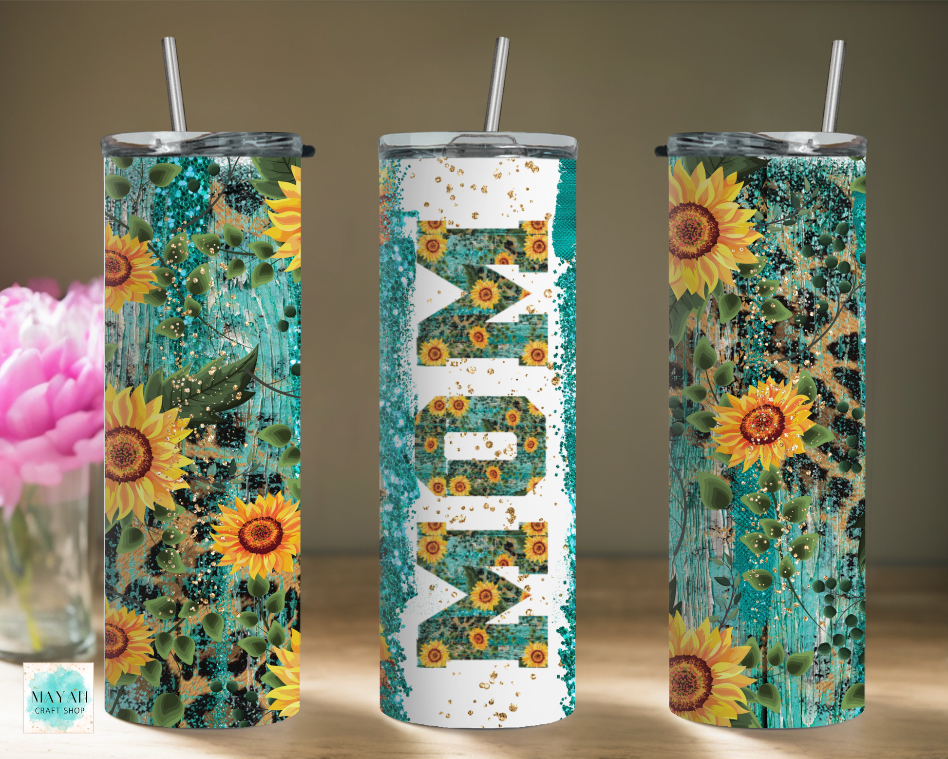 Three tumblers with sunflower designs on a wooden surface.