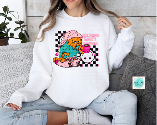 Person wearing a white sweatshirt with a colorful graphic design sitting on a couch.