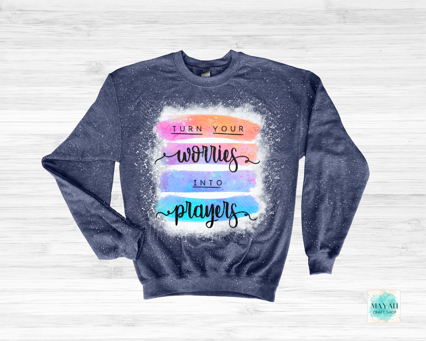 Navy sweatshirt with colorful text design on a light wooden background