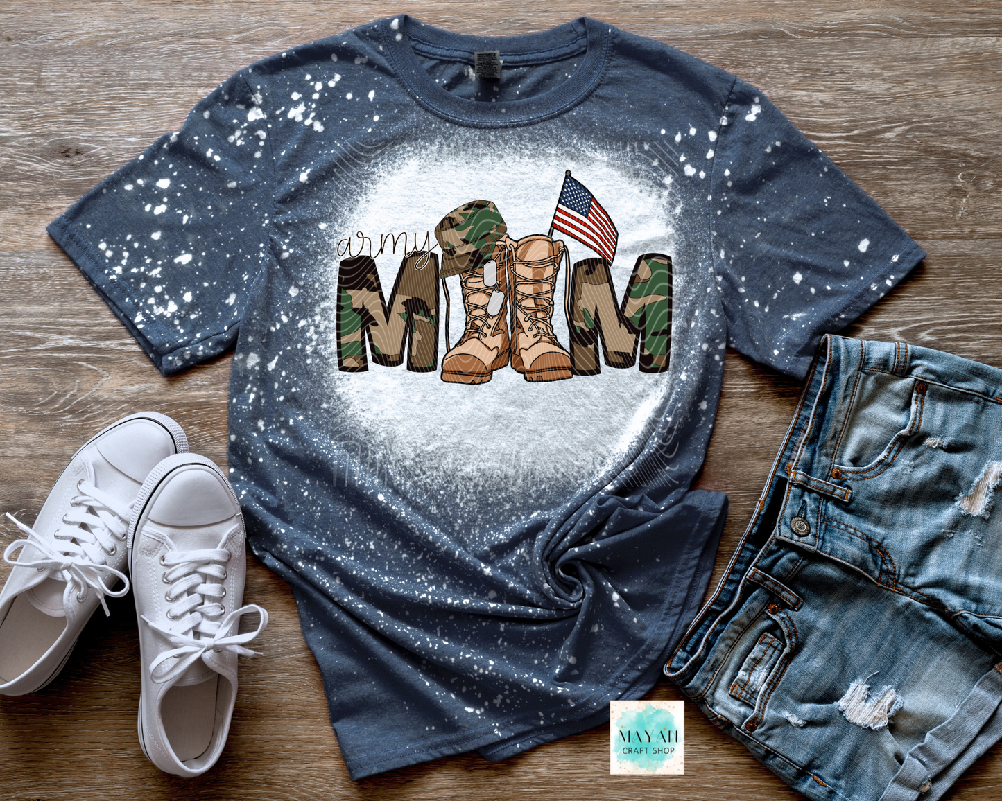 Navy blue t-shirt with military mom design on a wooden surface with white sneakers and jeans.