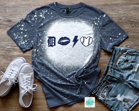Bleached t-shirt with graphic design on a wooden surface with sneakers and jeans.