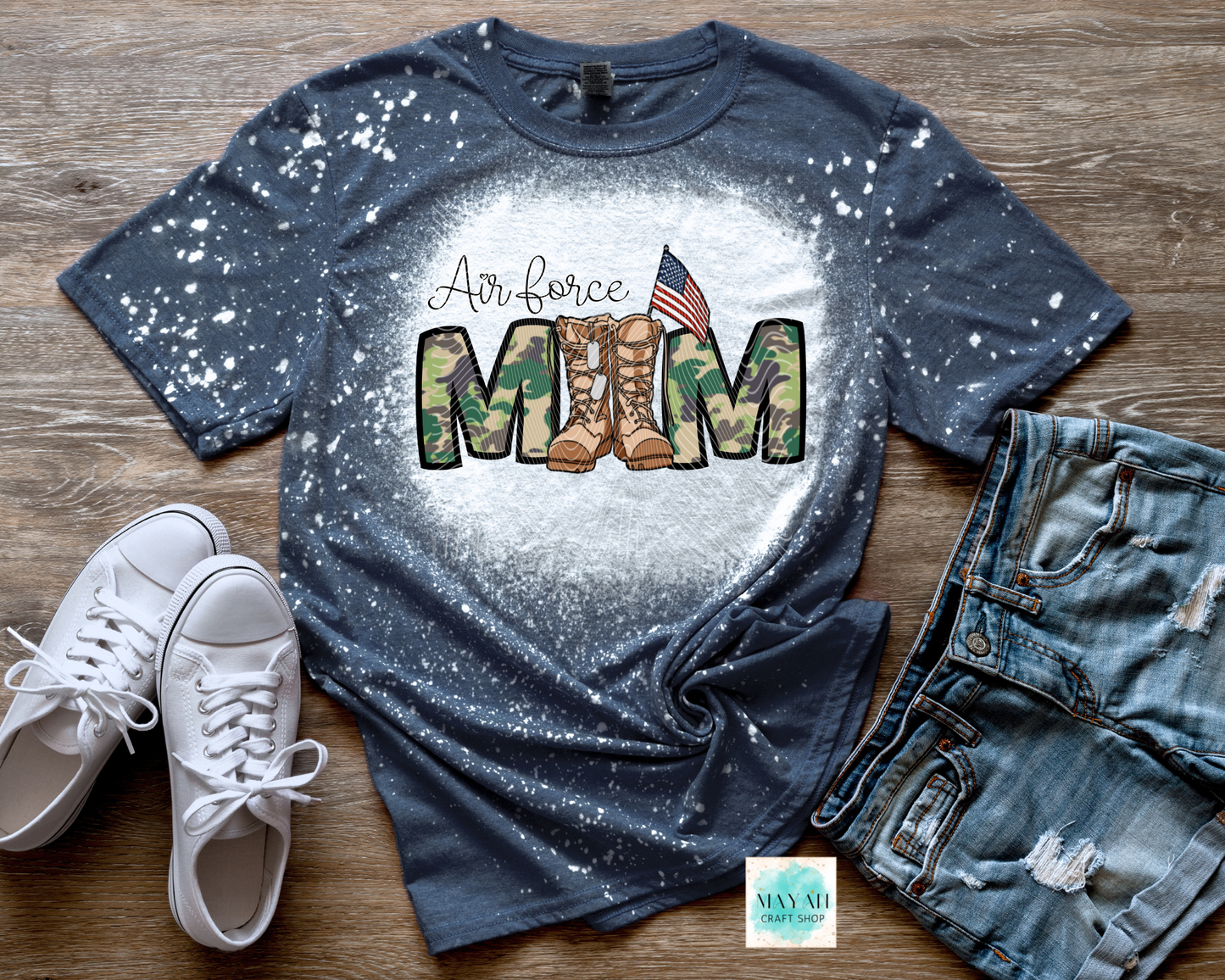 Navy blue t-shirt with military mom design on a wooden surface with white sneakers and jeans.