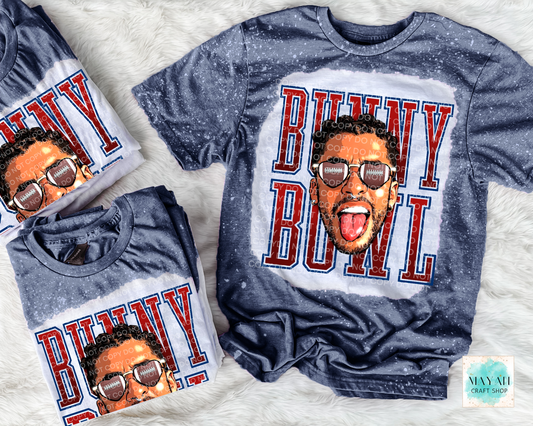 Two blue t-shirts with a graphic of a person and the text 'Bunny Bowl' on a white textured background.