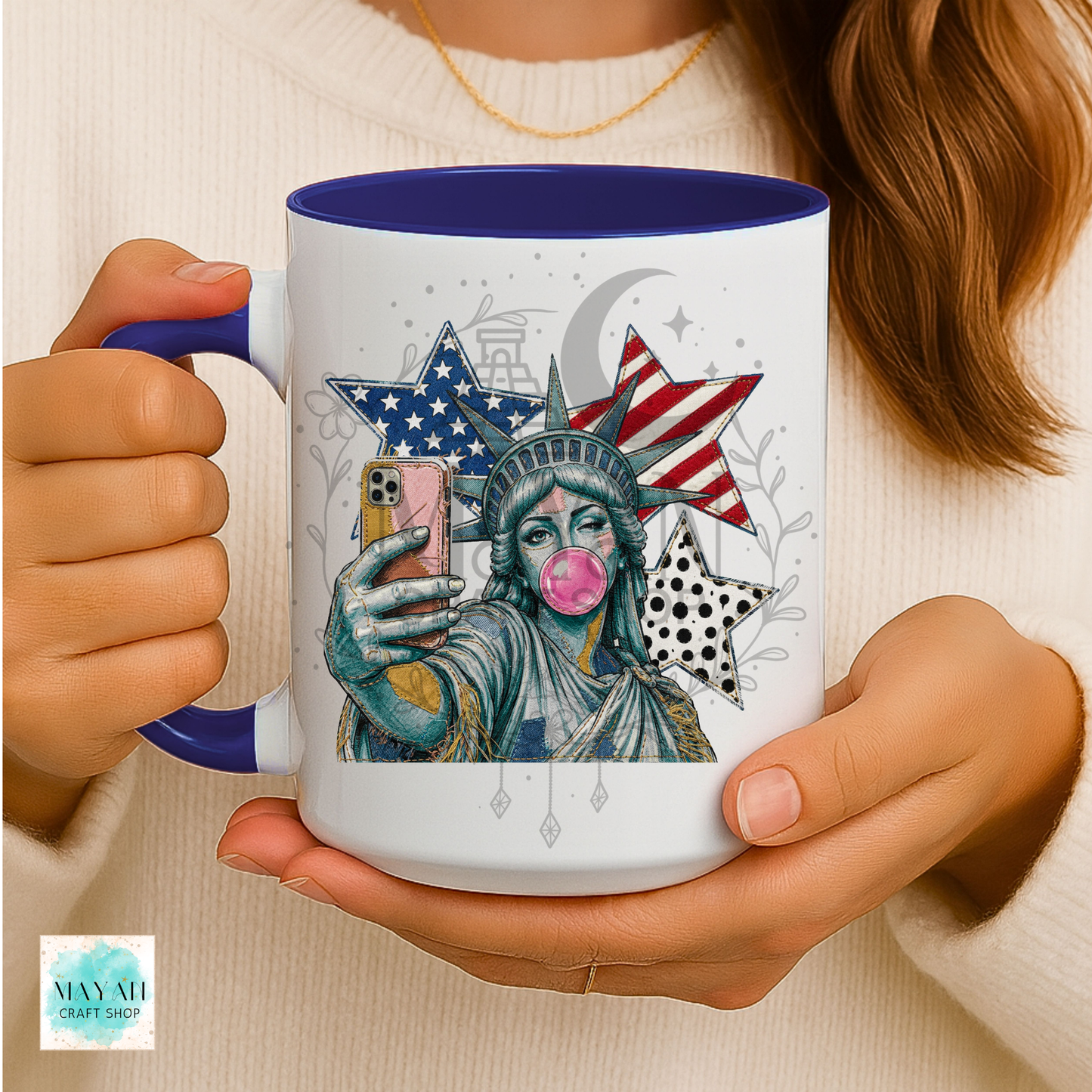 Person holding a mug with a colorful design of the Statue of Liberty taking a selfie.