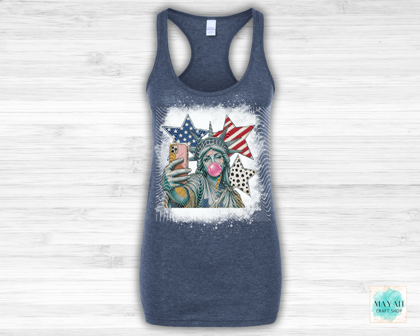 Blue tank top with a graphic of the Statue of Liberty wearing sunglasses and blowing a bubble, with American flags in the background.