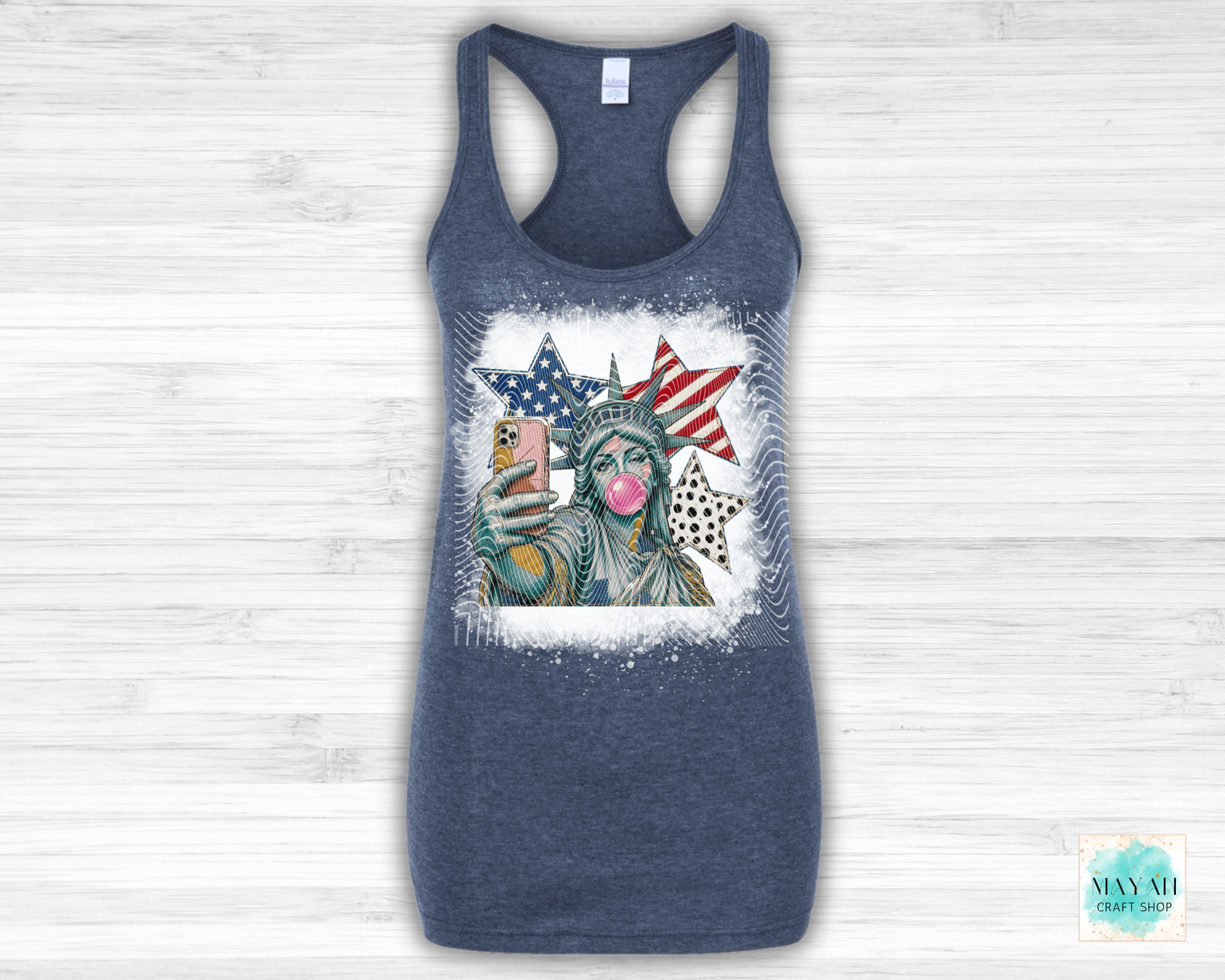 Blue tank top with a graphic of the Statue of Liberty wearing sunglasses and blowing a bubble, with American flags in the background.