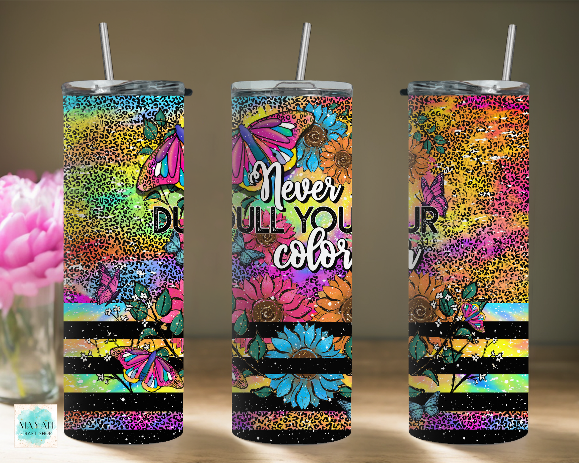 Three colorful tumblers with floral and abstract designs on a neutral background.