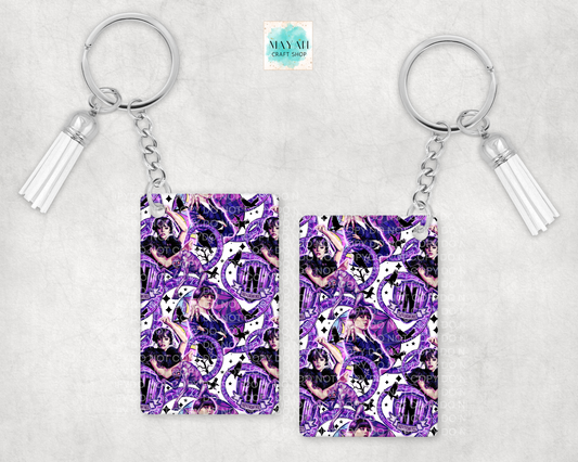 Two keychains with a purple and white pattern on a light gray background