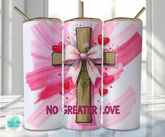 Three tumblers with a cross, bow, and hearts design on a pink background.