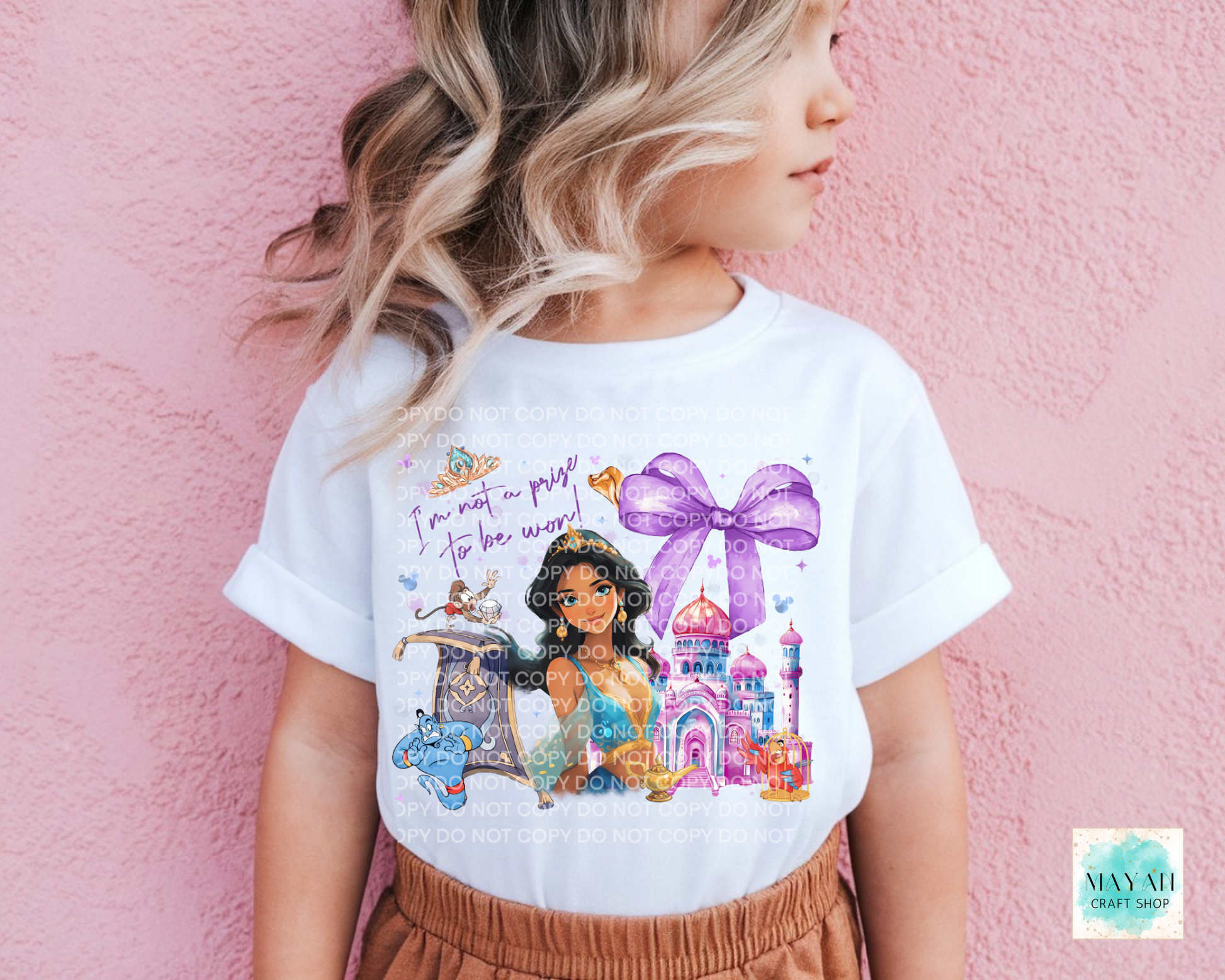 Child wearing a white t-shirt with a colorful graphic design against a pink background