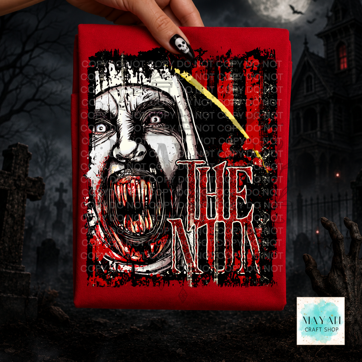 A hand holds a red shirt featuring a horror-style illustration of a screaming nun with vampire fangs and words in large distressed lettering. The background is a dark gothic graveyard scene with a haunted house, tombstones, and a zombie hand.