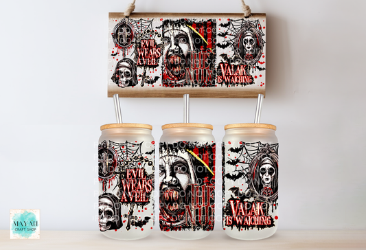 Three frosted glass mason jar tumblers with light wood lids and metal straws, printed with a horror-themed gothic graphic featuring skulls, bats, spiders. A matching rectangular print hangs above the tumblers on a light wall.
