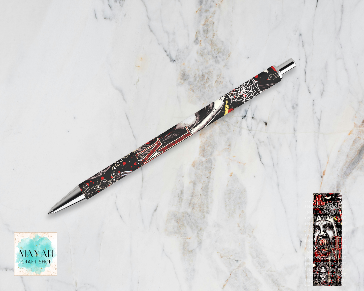 A Halloween-themed ballpoint pen with a black, white, and red spider-themed design, displayed diagonally on a white marble background and a product detail inset on the bottom-right.