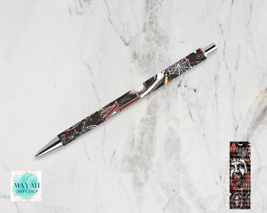 A Halloween-themed ballpoint pen with a black, white, and red spider-themed design, displayed diagonally on a white marble background and a product detail inset on the bottom-right.