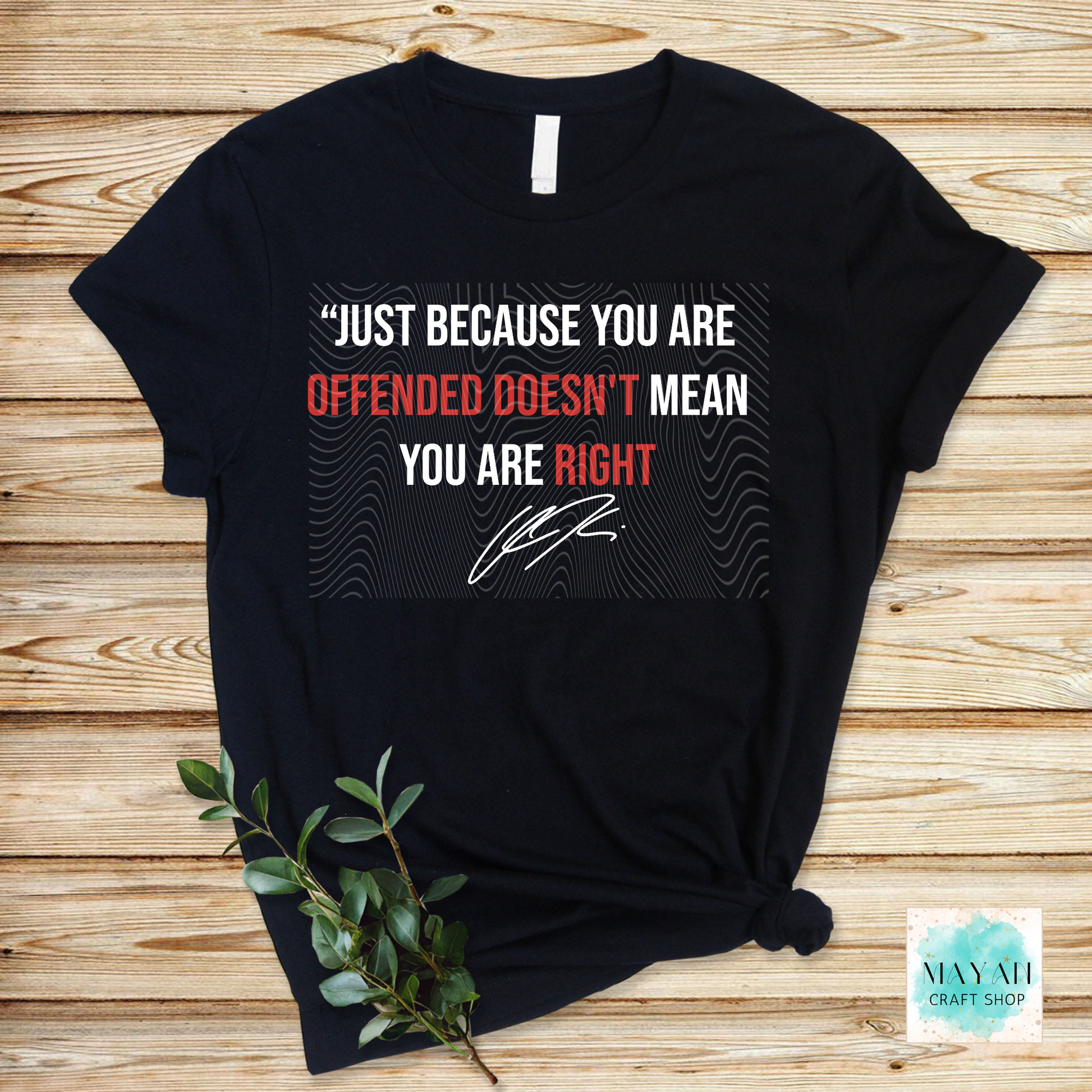Black t-shirt with a printed message on a wooden surface