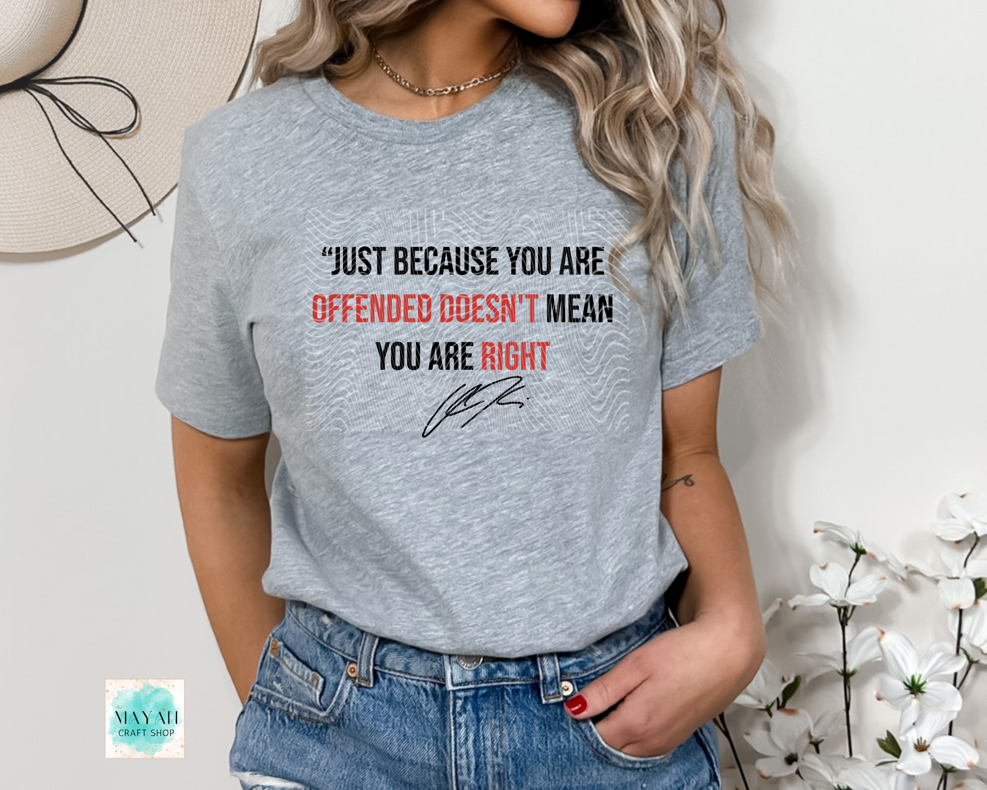 Person wearing a gray t-shirt with a printed message and floral background