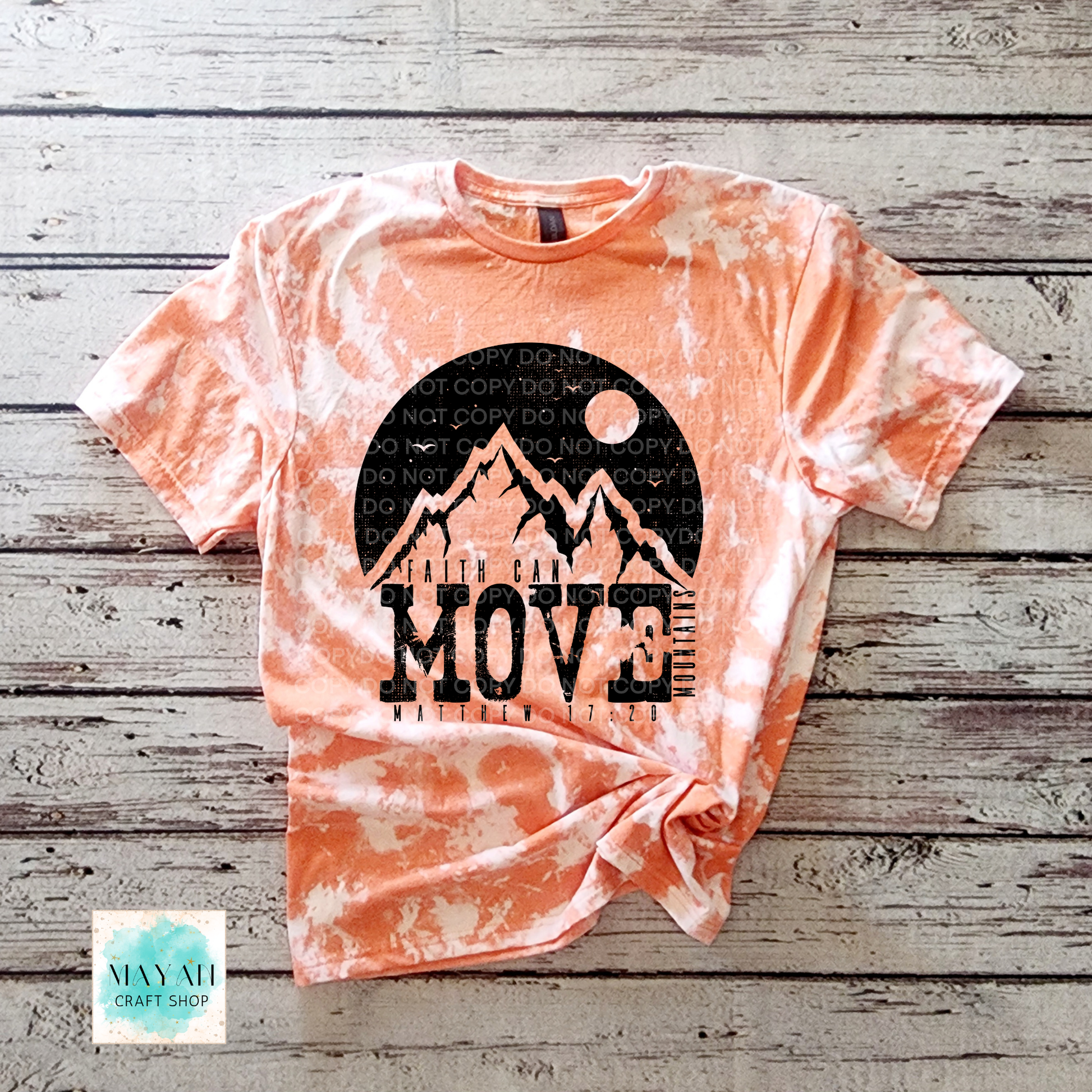 Tie-dye t-shirt with mountain graphic and 'MOVE' text on a wooden surface