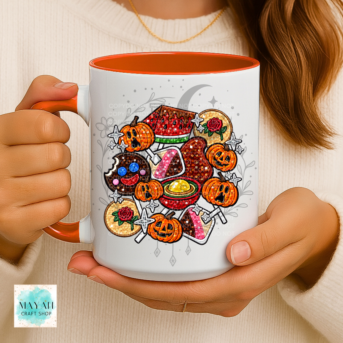A person holds a white ceramic mug with an orange handle and interior. The mug features a colorful Halloween-themed graphic with mexican candy.