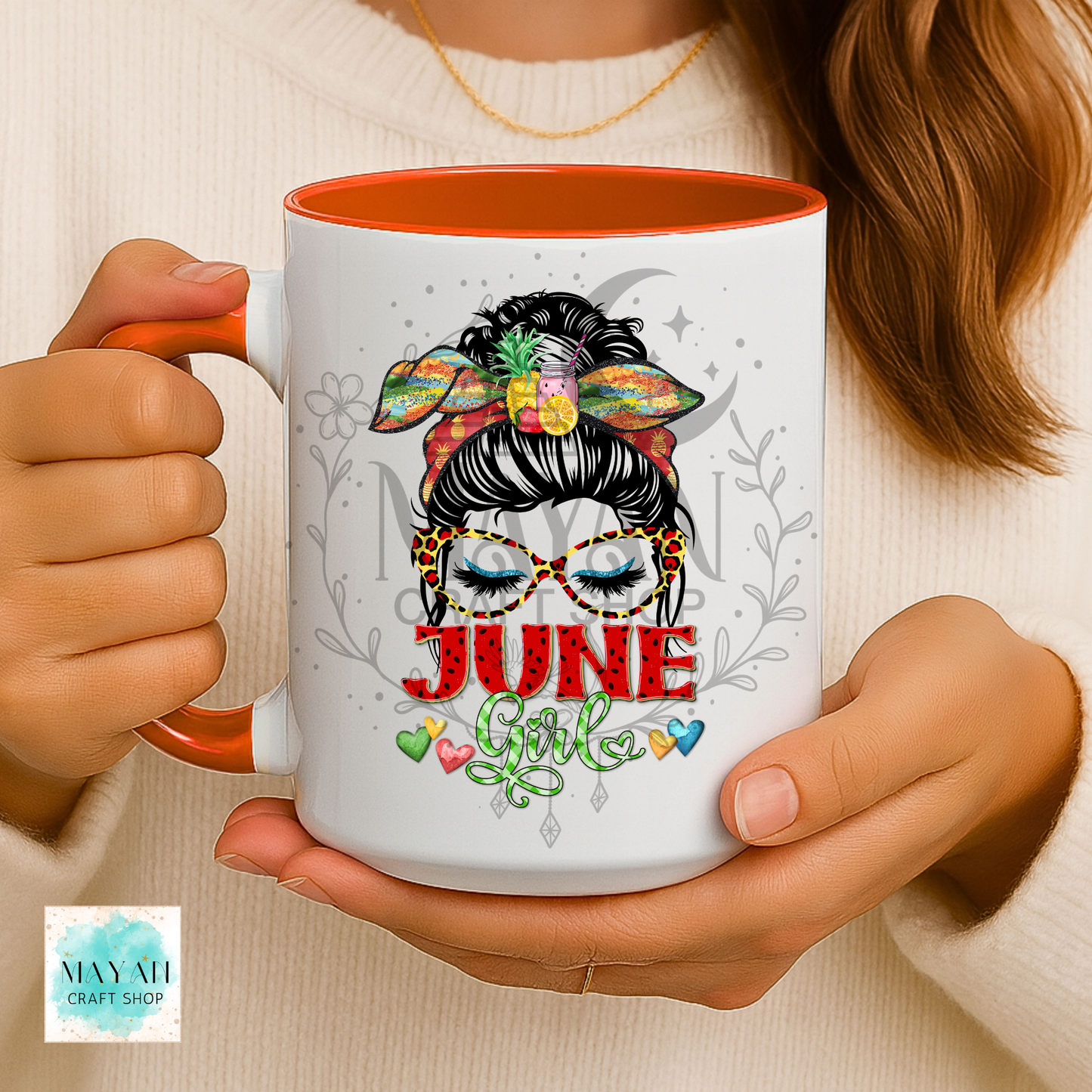 Person holding a mug with 'June Girl' design and floral elements.