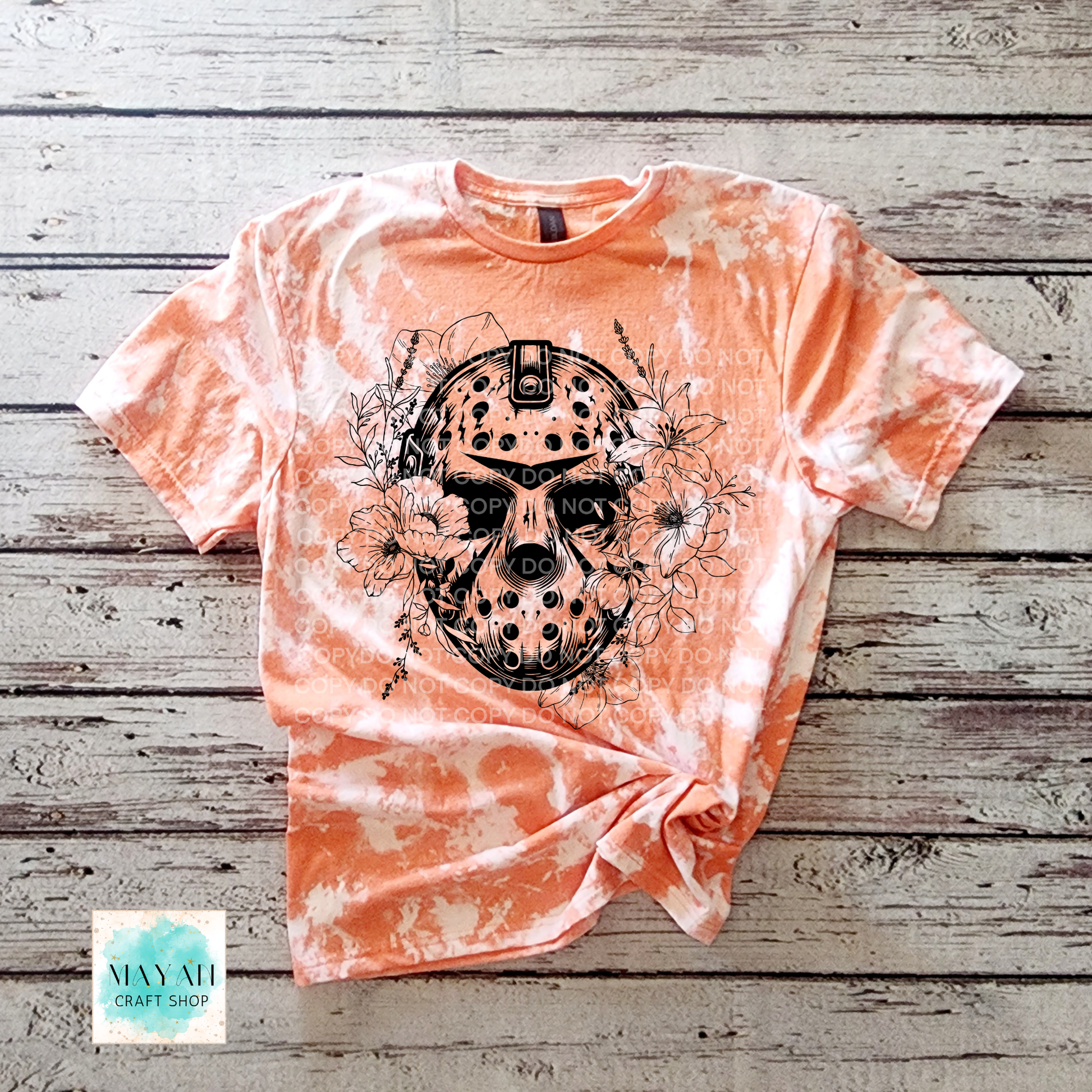 Tie-dye t-shirt with a skull design on a wooden surface.