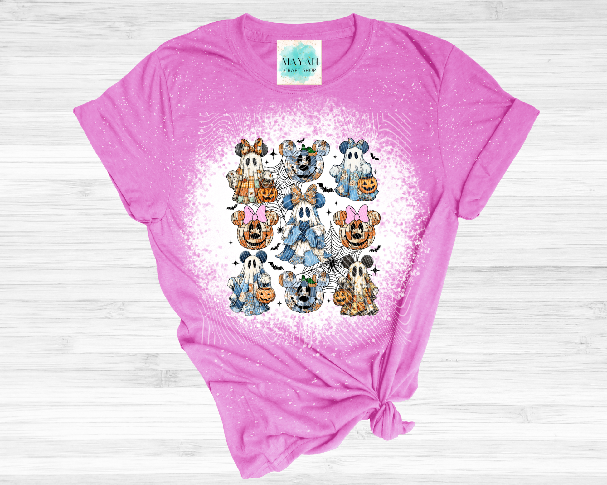 Pink t-shirt with Halloween-themed graphic design on a wooden surface
