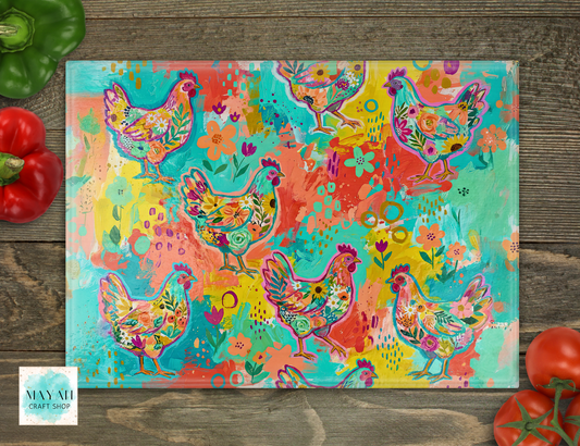 Colorful cutting board with floral chicken design on a wooden surface with vegetables.
