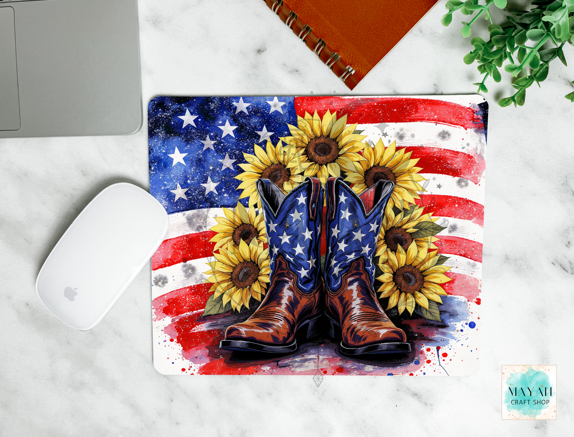 Mouse pad with American flag design, cowboy boots, and sunflowers on a marble surface.