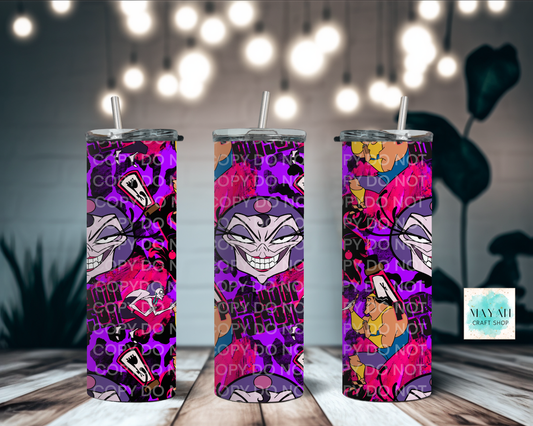 Three colorful tumblers with a design on a wooden surface with blurred lights in the background.