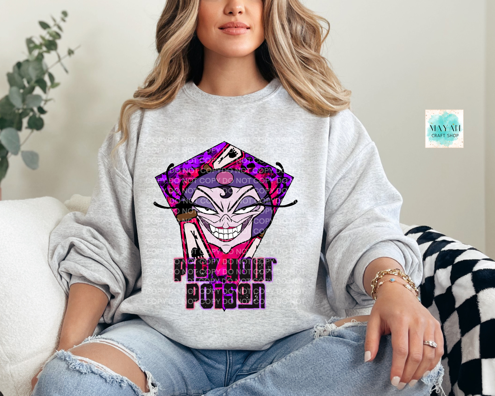 Person wearing a gray sweatshirt with a graphic design and text, sitting on a couch.