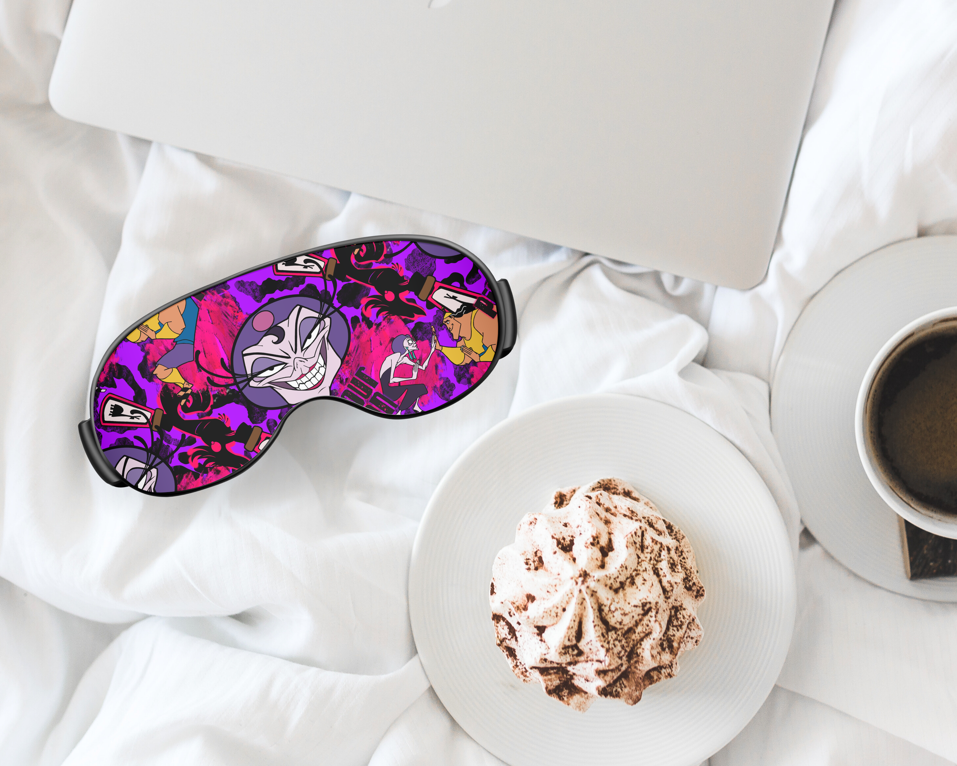 Colorful sleep mask on a white surface with a plate of food and a cup of coffee.