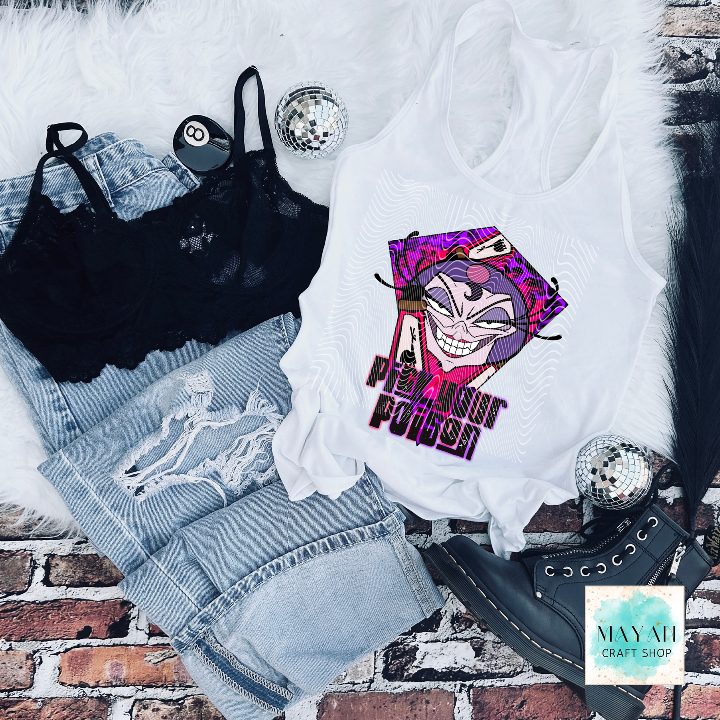 White tank top with graphic design, black bralette, denim shorts, and black shoes on a brick surface.