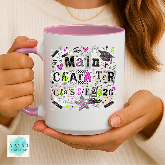 Person holding a mug with 'Main Character Class of 2026' design, with a visible brand logo in the corner.