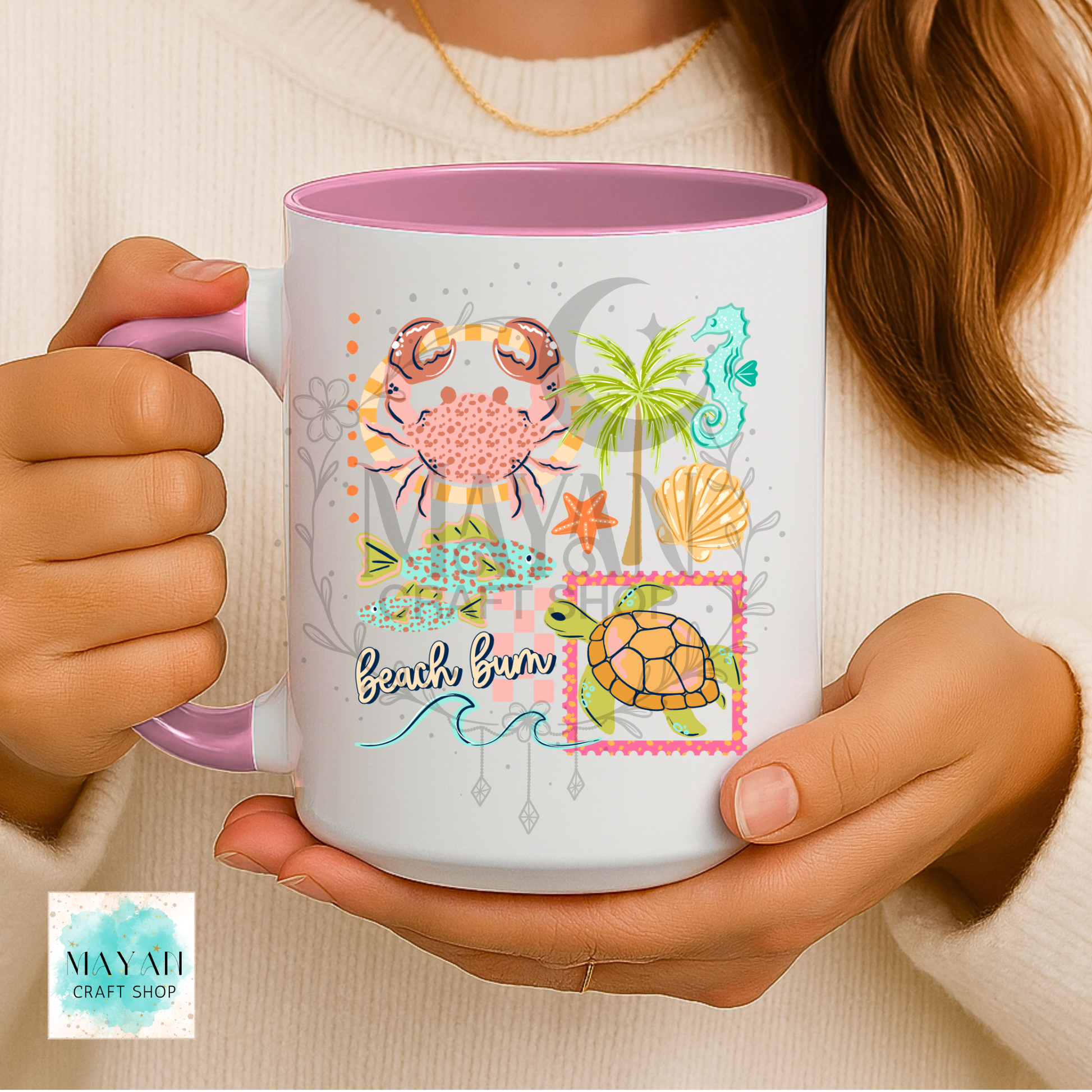 Person holding a mug with beach-themed design featuring a turtle, palm tree, and seashells.