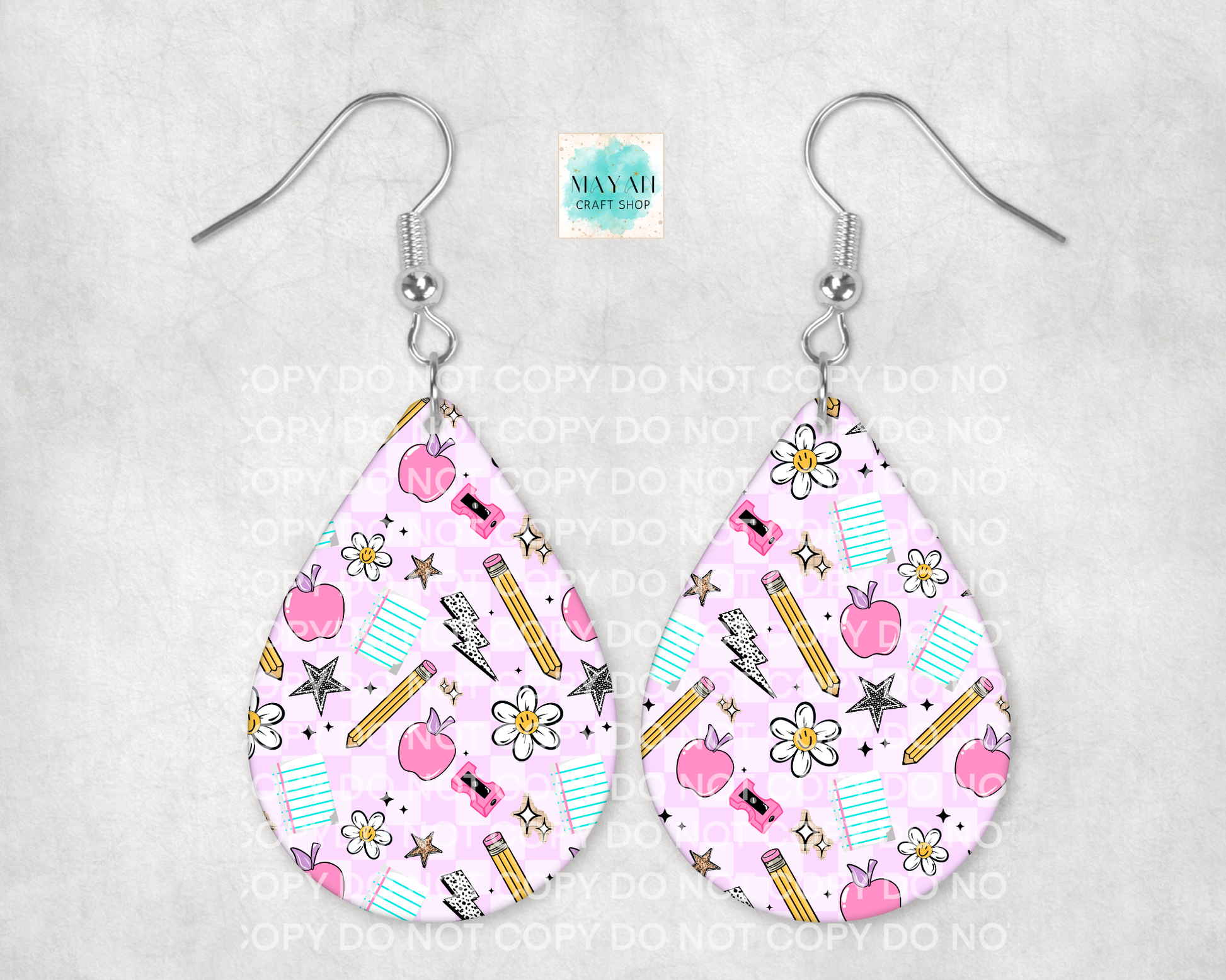 Teardrop-shaped earrings with a pink pattern featuring apples, pencils, and flowers on a gray background.
