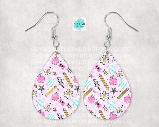 Teardrop-shaped earrings with a pink pattern featuring apples, pencils, and flowers on a gray background.