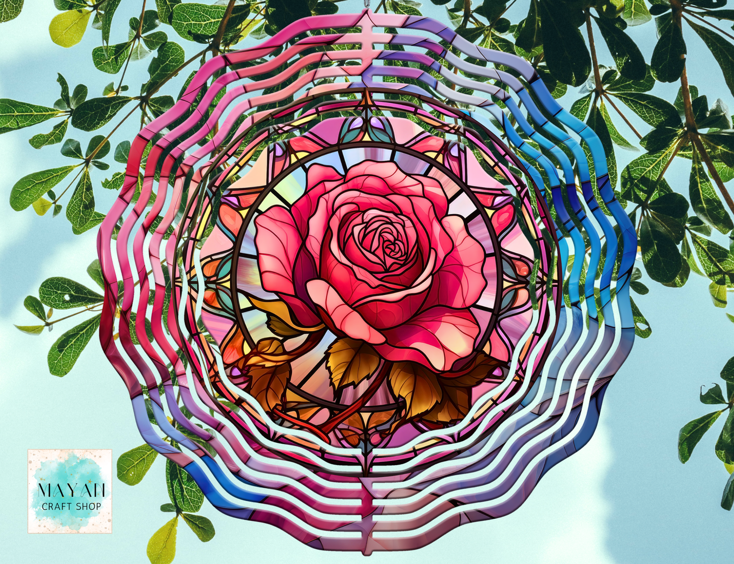 Colorful rose-shaped wind spinner against a natural background.