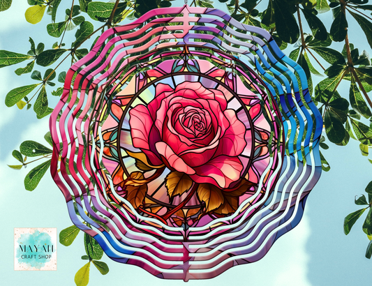 Colorful rose-shaped wind spinner against a natural background.