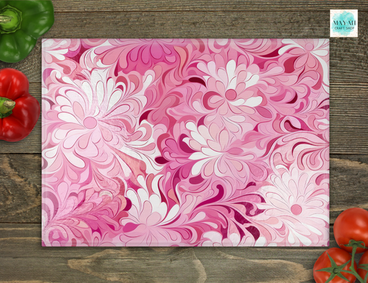 Floral patterned cutting board on a wooden surface with vegetables around