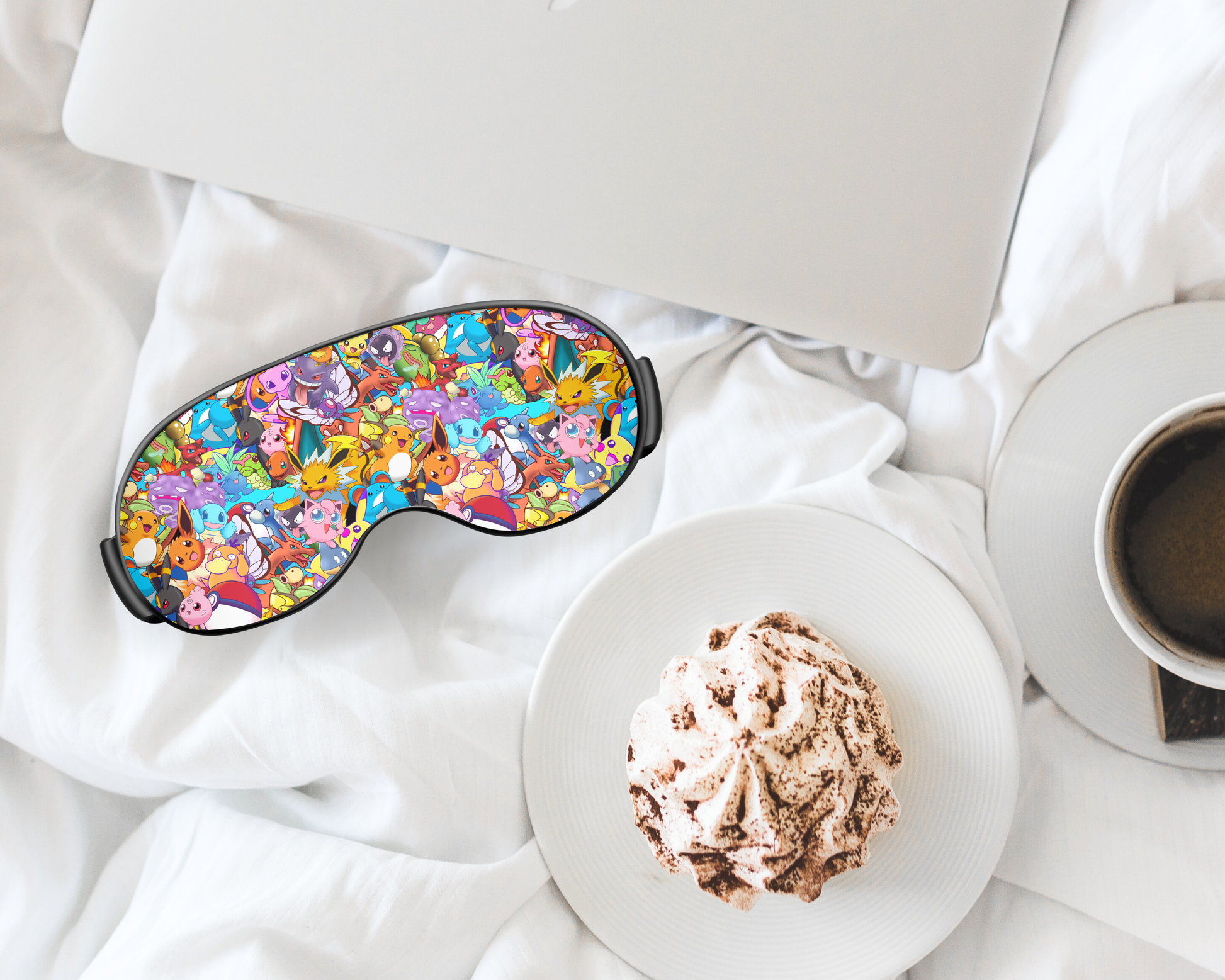 Colorful sleep mask on a white surface with a plate of food and a cup of coffee.