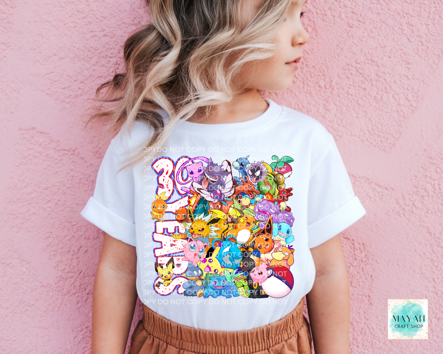 Person wearing a white t-shirt with colorful graphic design against a pink background