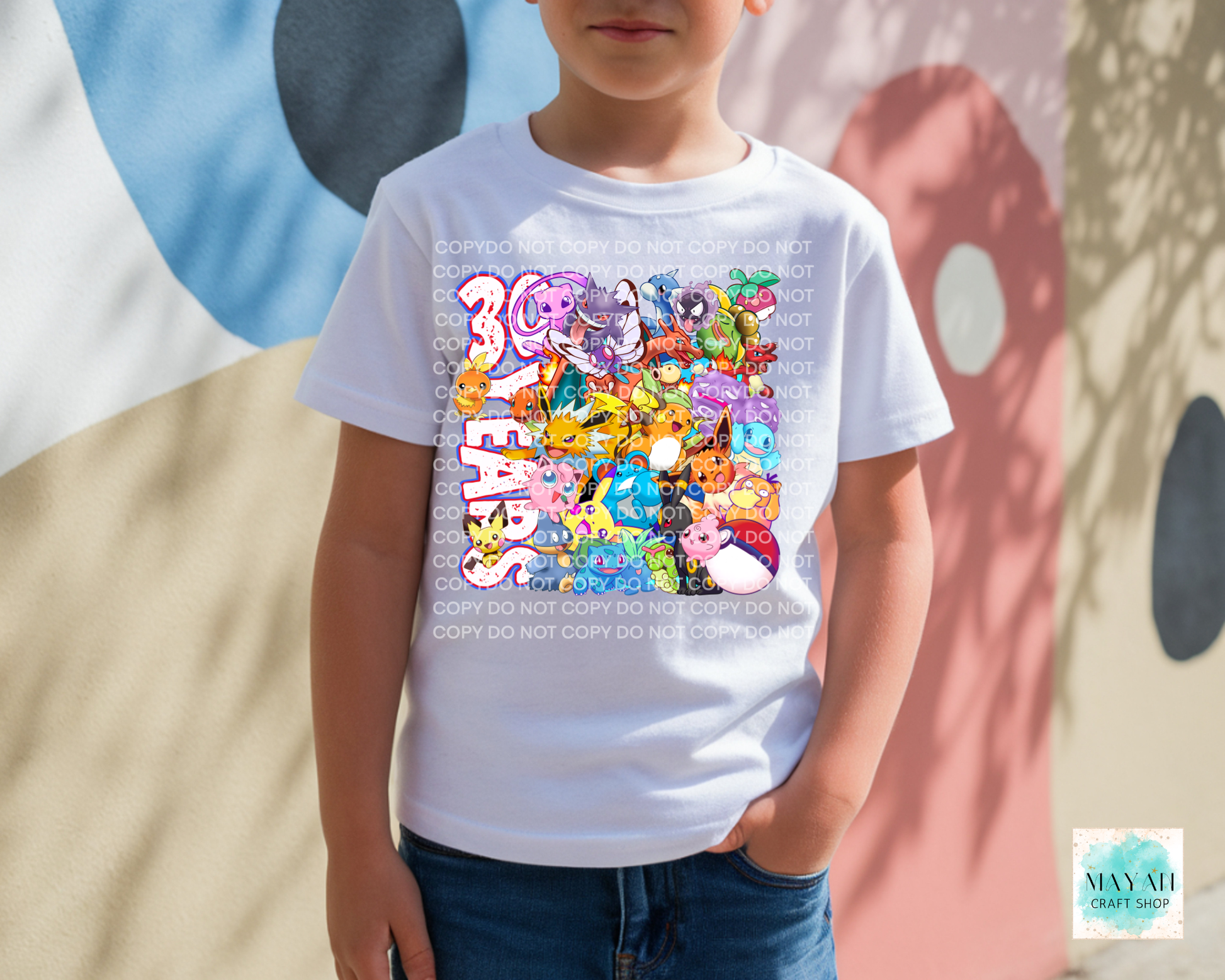 Child wearing a white t-shirt with colorful graphic design and text, standing against a multicolored abstract background.