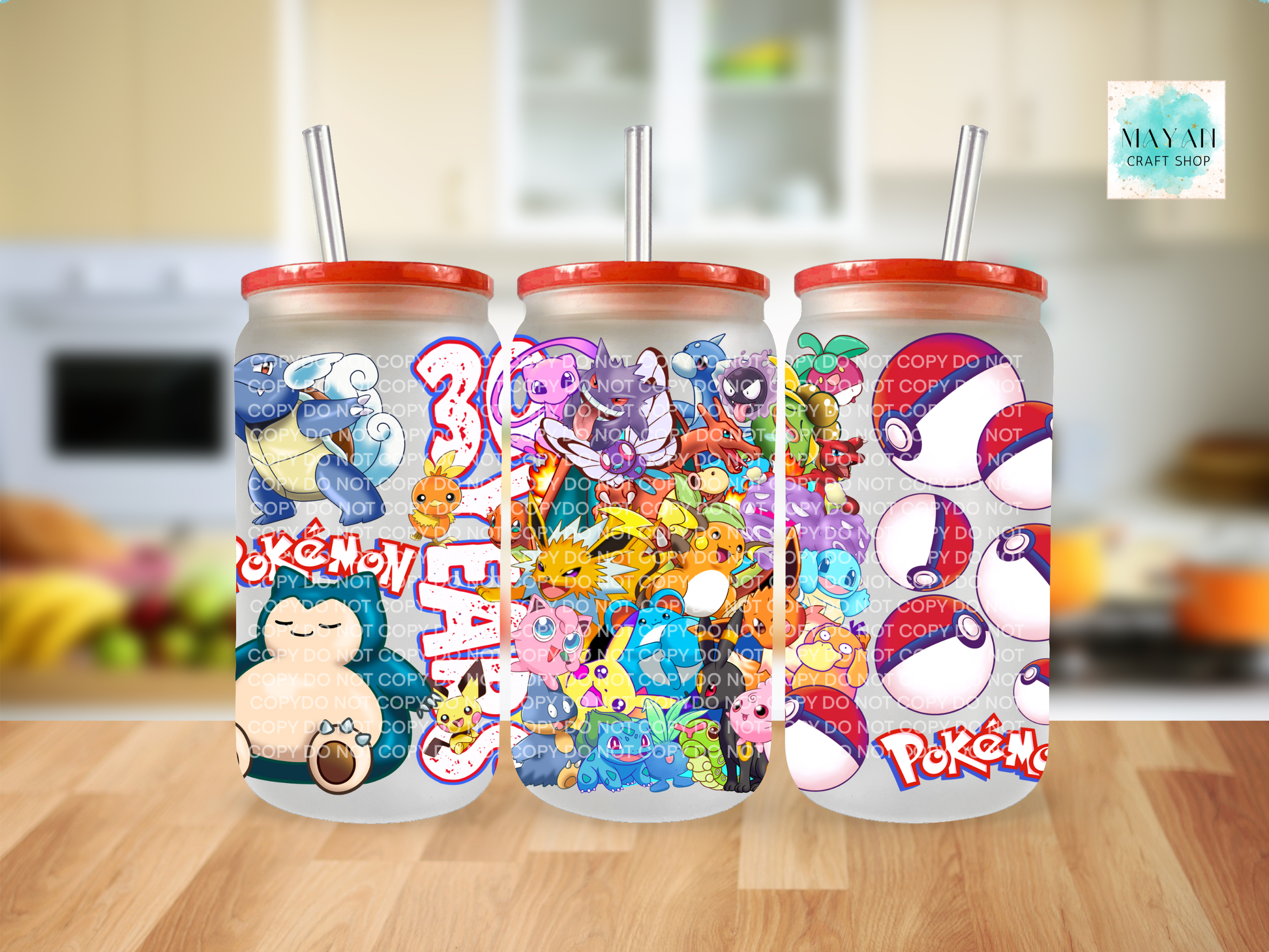 Three colorful tumblers with cartoon designs on a wooden surface.