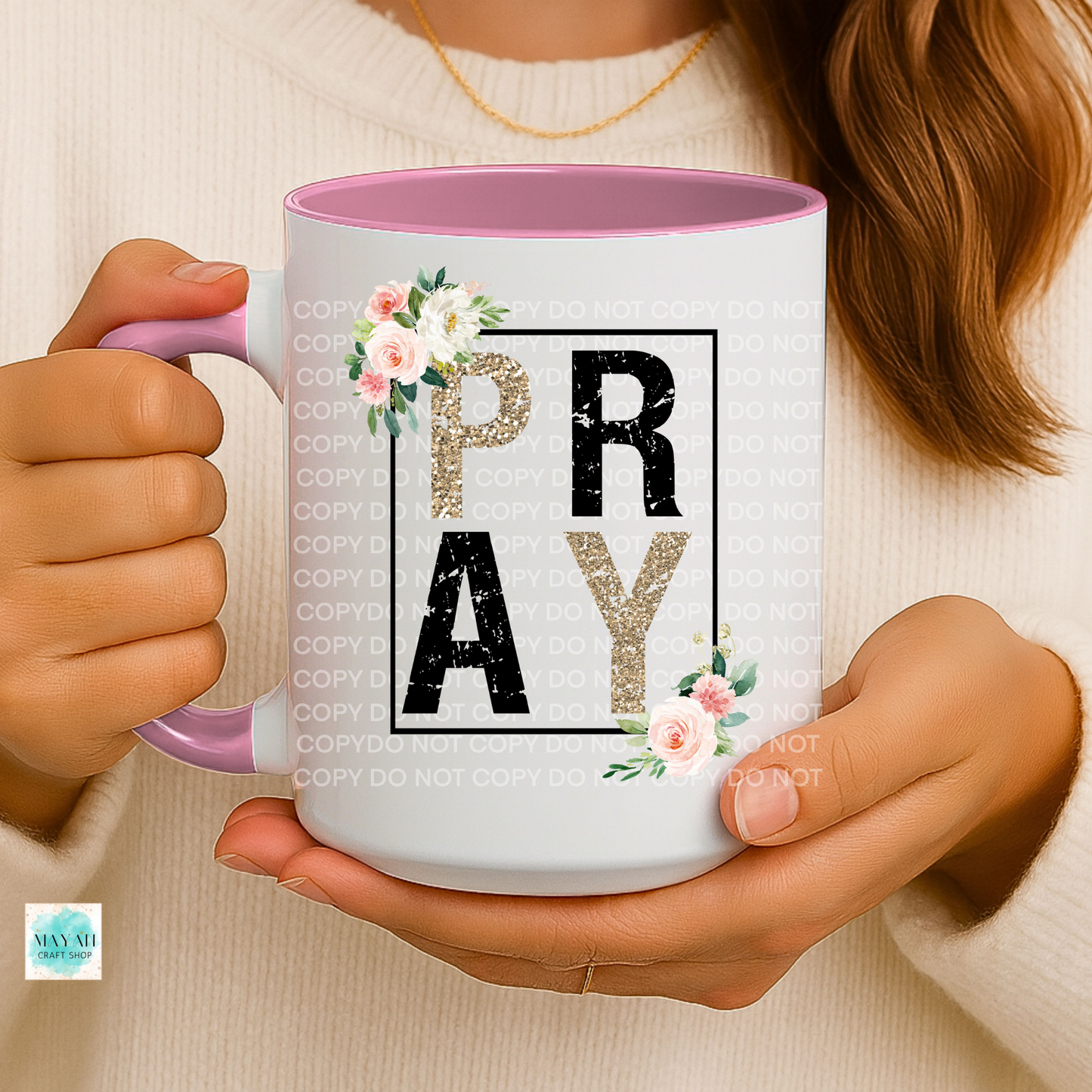 Person holding a mug with 'PRAY' text and floral designs.