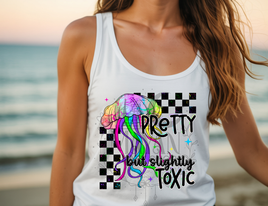Person wearing a white tank top with colorful design and text on a beach.