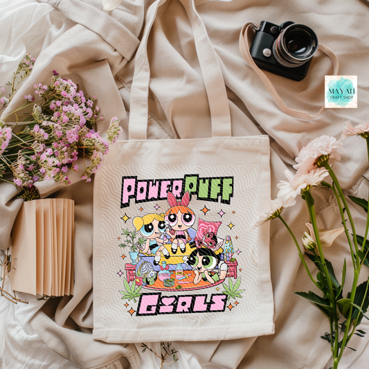 Tote bag with cartoon characters on a light fabric background with flowers and a camera.