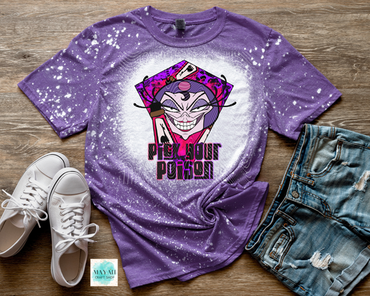 Purple t-shirt with a graphic design and text, paired with white sneakers and denim shorts on a wooden surface.