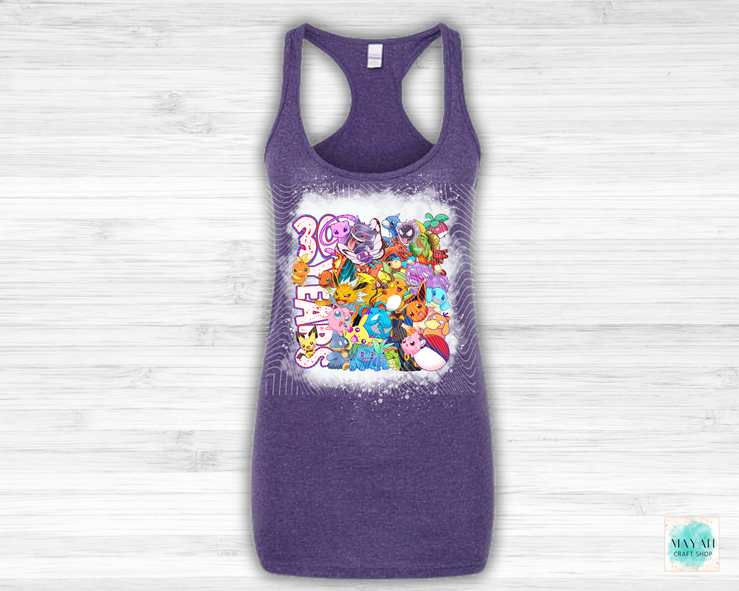 Purple tank top with cartoon character design on a light wooden background