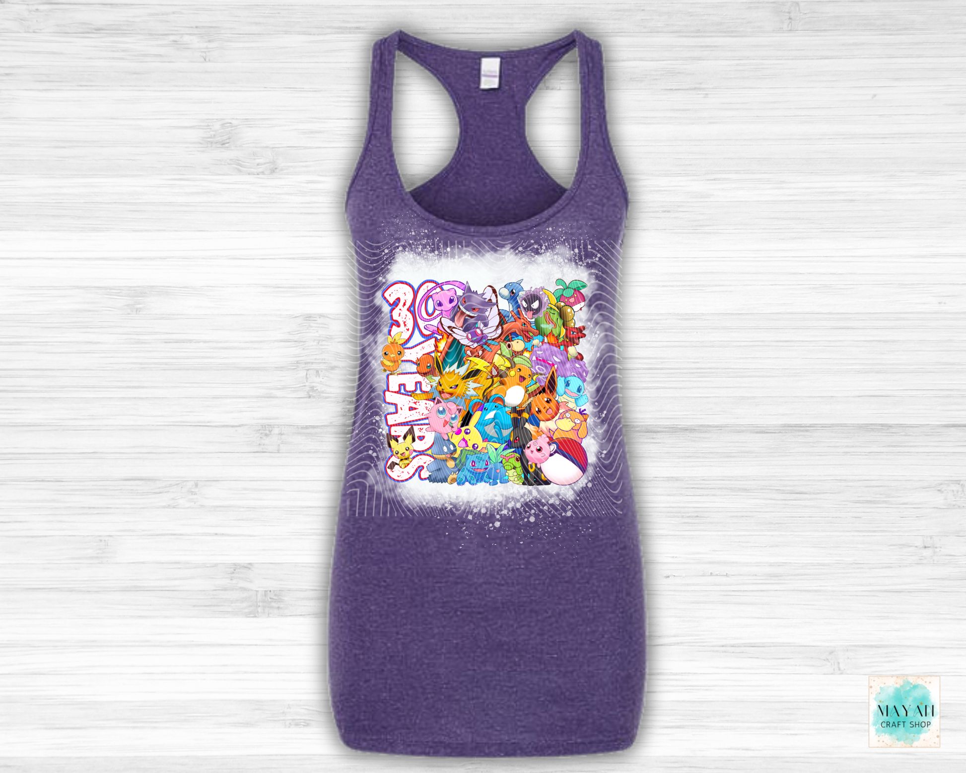 Purple tank top with cartoon character design on a light wooden background